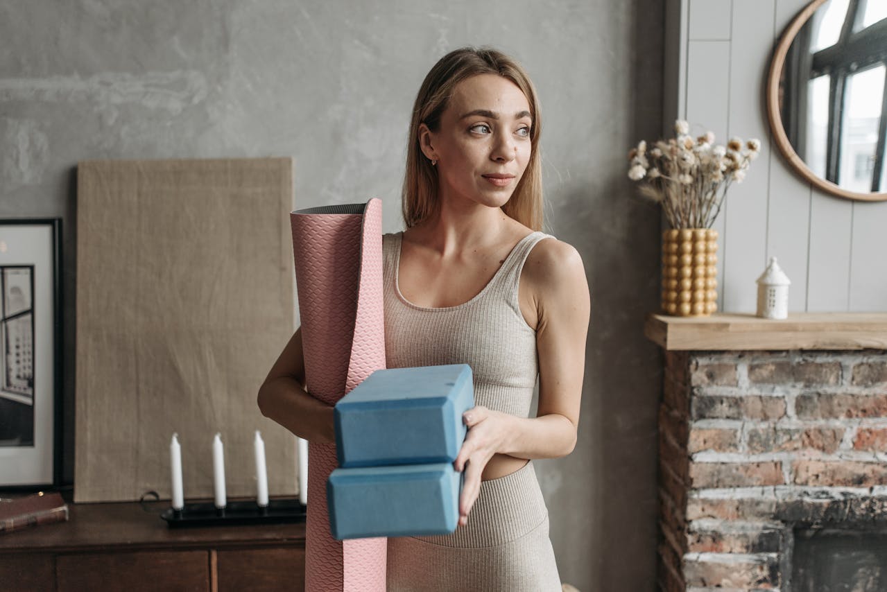 Woman holding yoga equipment and looking content